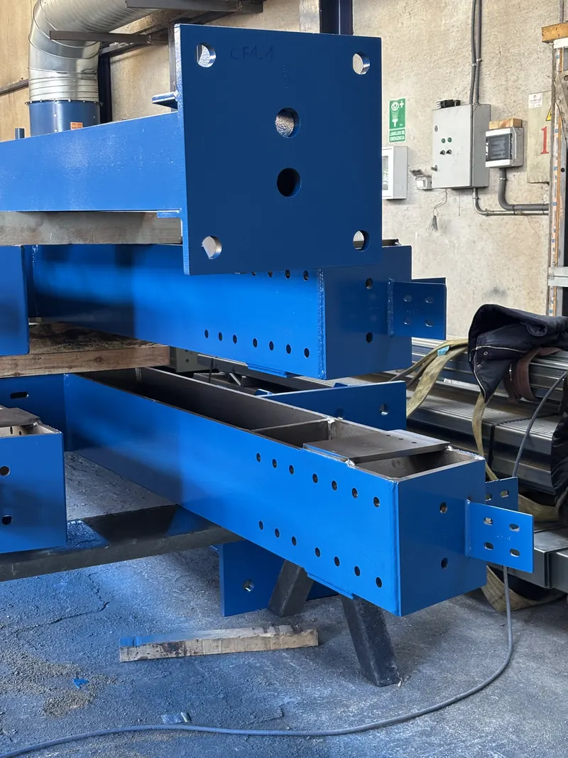 Piezas de estructura con la pintura de acabado en azul, en el taller de Luvimetal